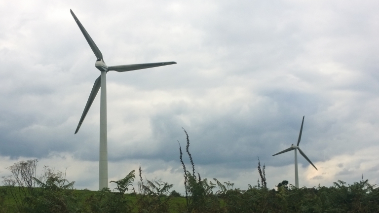 Wind turbines loom over the Breton hills.